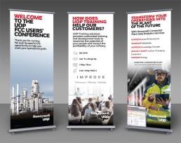 Three Honeywell UOP banners. The first welcomes attendees to the FCC Conference with an image of an oil refinery. The second promotes training with icons and text. The third discusses transforming operations, featuring a worker using a tablet.